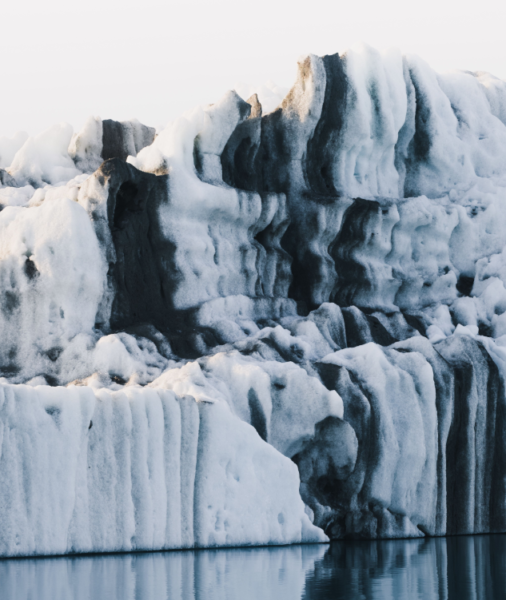 A close-up of a humbug iceberg, with black stripes steaking through the white ice 