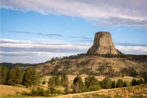 Devils Tower, a flat rocky butte stands tall above the surrounding land.