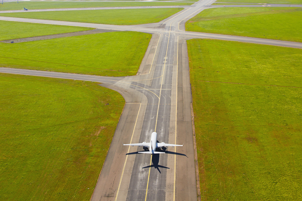 Aerial view of airport - airplane is taxiing to take off
