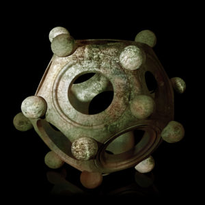 Ancient bronze Roman dodecahedron on a black background