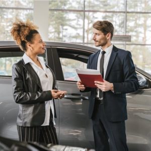 A woman selling a car to a man.