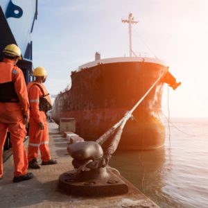 A haulage ship at the port surrounded by construction workers.