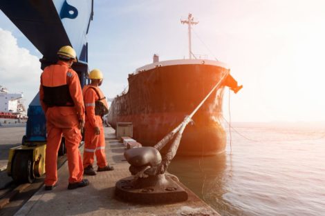 A haulage ship at the port surrounded by construction workers.